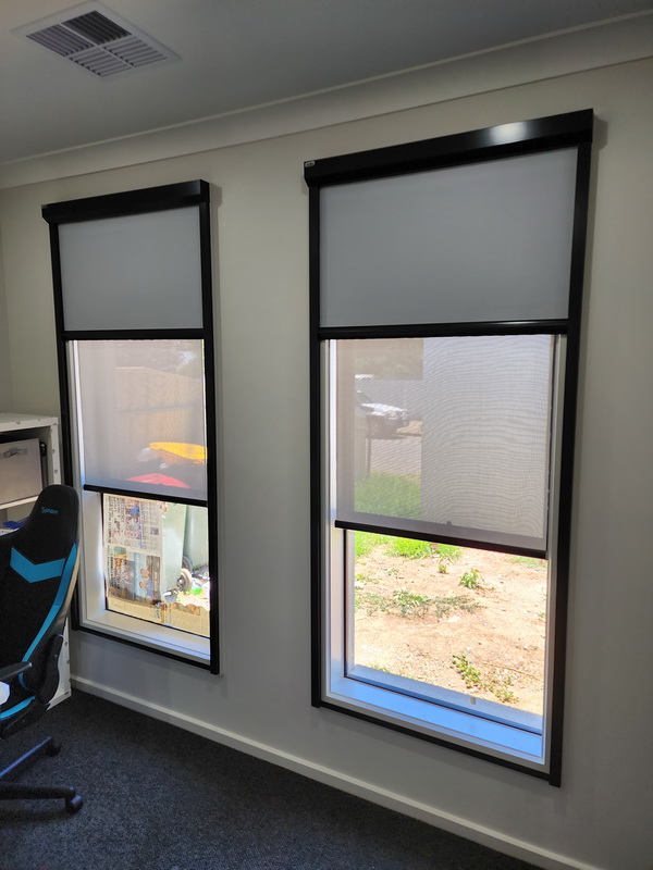 office room with windows with roller blinds half closed