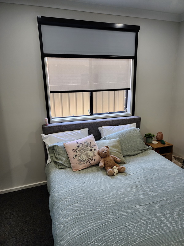 bedroom with roller blinds half closed